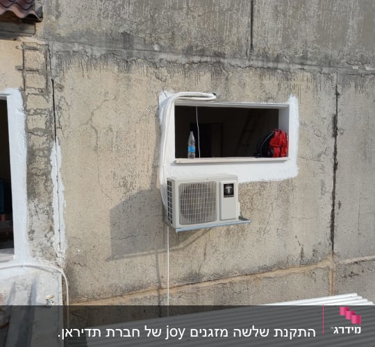 יחידת מזגן חיצונית מותקנת על קיר בטון